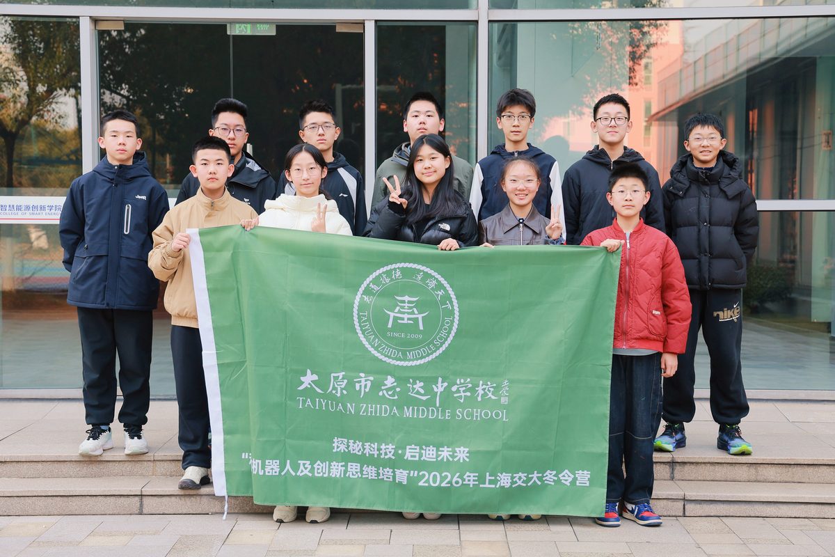太原市志达中学校学生举着校旗在上海交大合影